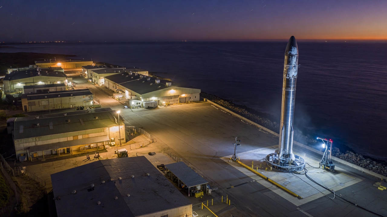 An oceanside industrial campus at night